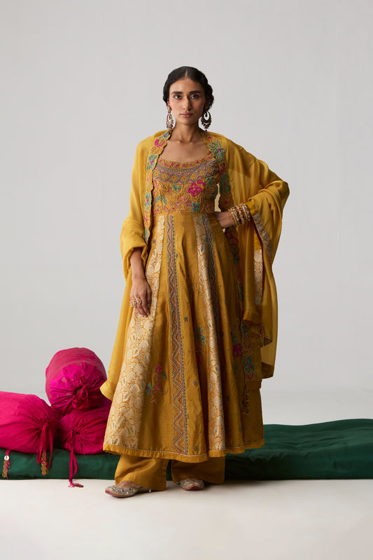 Nehmat – mustard embroidered yoke Anarkali with Banarasi raw silk panels and organza dupatta by Julie & Rinki